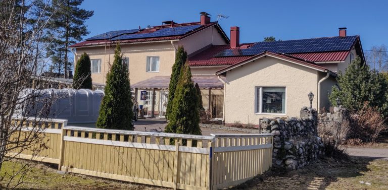 Suuri omakotitalo, jonka katolla aurinkopaneeleita