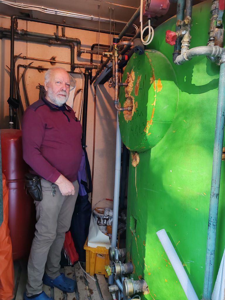 Mies lämmitysjärjestelmän vieressä