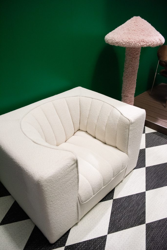 Valkoinen nojatuoli ja karvakankainen lamppu