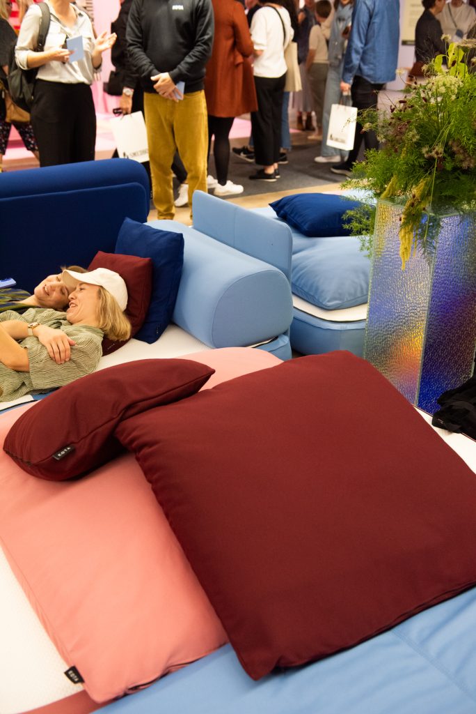 Kaksi ihmistä makoilemassa muhkeiden tyynyjen keskellä