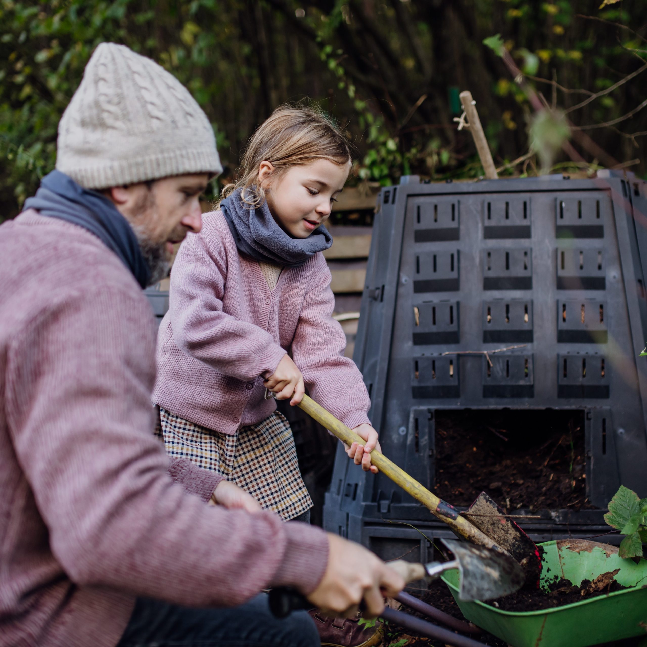 Isä ja tytär hoitavat kompostia.