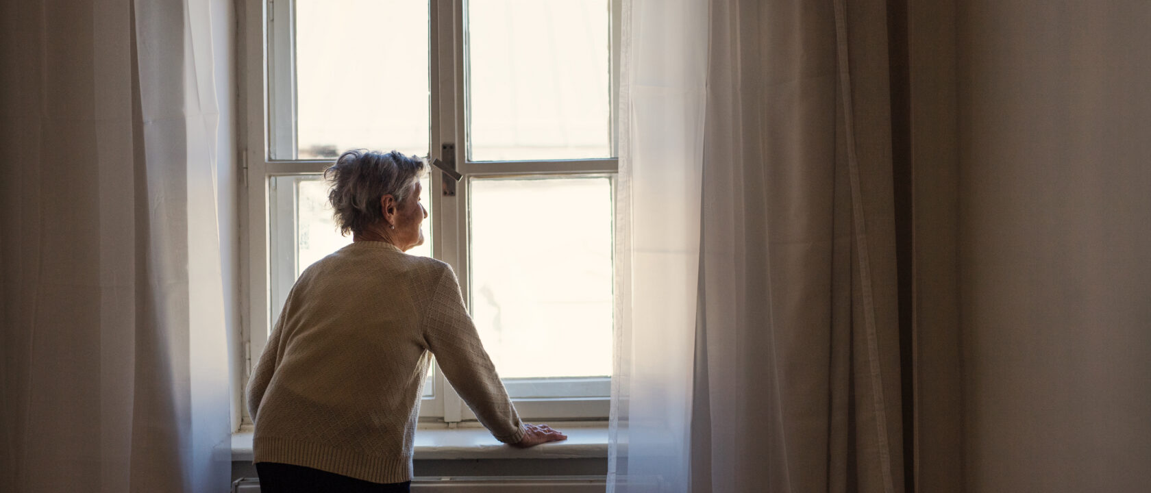 Ikkunasta ulos katseleva vanha nainen